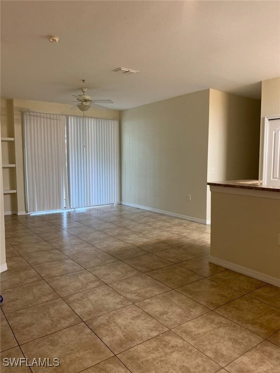 6169 Metrowest Blvd Unit 104, Orlando, FL 32835 - unfurnished room featuring a ceiling fan, baseboards, and light tile patterned floors