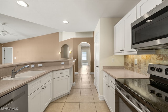2933 NW 25th Ter, Cape Coral, FL 33993 - kitchen featuring stainless steel appliances, light tile patterned flooring, arched walkways, a ceiling fan, and backsplash