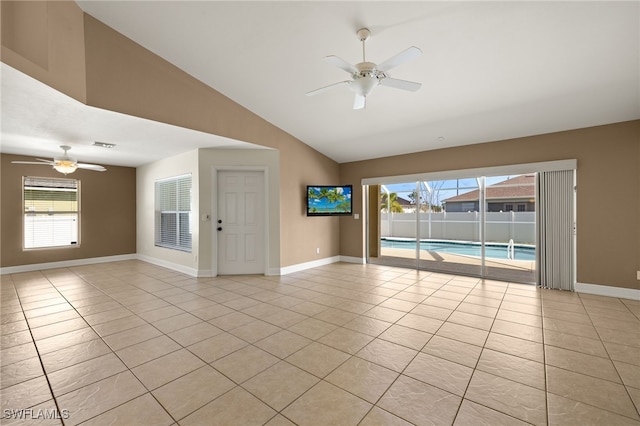 2933 NW 25th Ter, Cape Coral, FL 33993 - empty room with a ceiling fan, vaulted ceiling, light tile patterned floors, and healthy amount of natural light