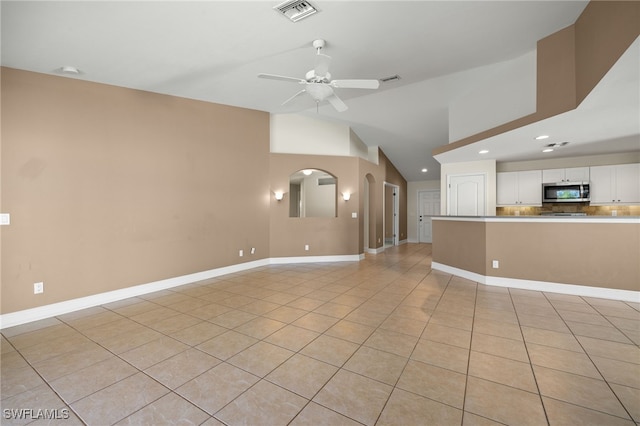 2933 NW 25th Ter, Cape Coral, FL 33993 - unfurnished living room featuring light tile patterned floors, vaulted ceiling, ceiling fan, recessed lighting, and arched walkways