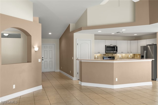 2933 NW 25th Ter, Cape Coral, FL 33993 - kitchen featuring stainless steel appliances, white cabinetry, arched walkways, decorative backsplash, and lofted ceiling