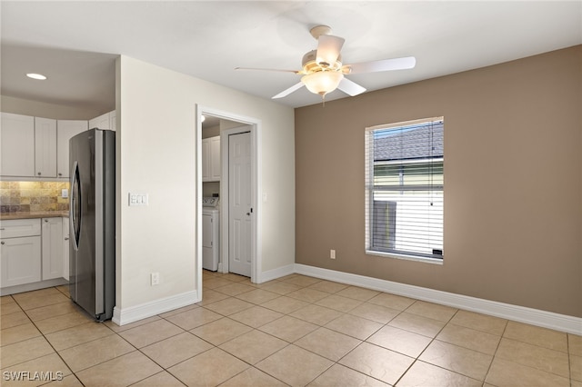 2933 NW 25th Ter, Cape Coral, FL 33993 - kitchen featuring freestanding refrigerator, washer / dryer, white cabinetry, ceiling fan, and backsplash
