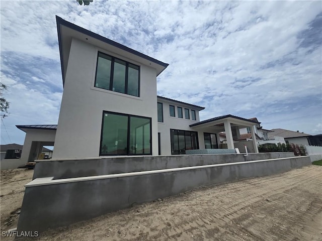 109 S Seas Ct, Marco Island, FL 34145 - back of property featuring stucco siding, a standing seam roof, and metal roof