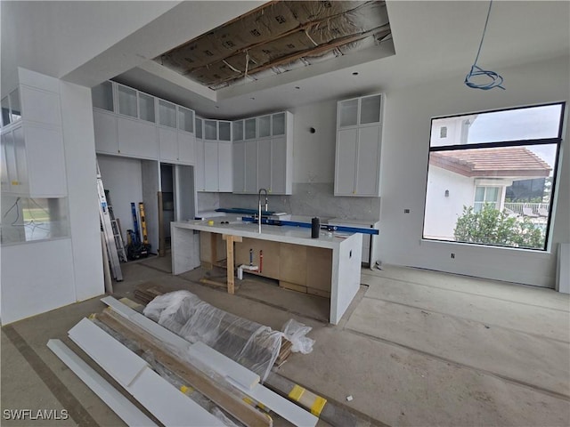 109 S Seas Ct, Marco Island, FL 34145 - kitchen with a sink, white cabinetry, a kitchen island with sink, light countertops, and a breakfast bar