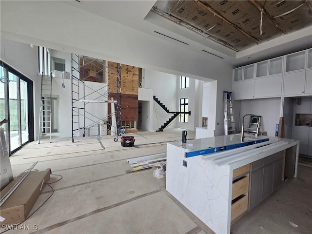 109 S Seas Ct, Marco Island, FL 34145 - kitchen with concrete floors, an island with sink, modern cabinets, and white cabinetry