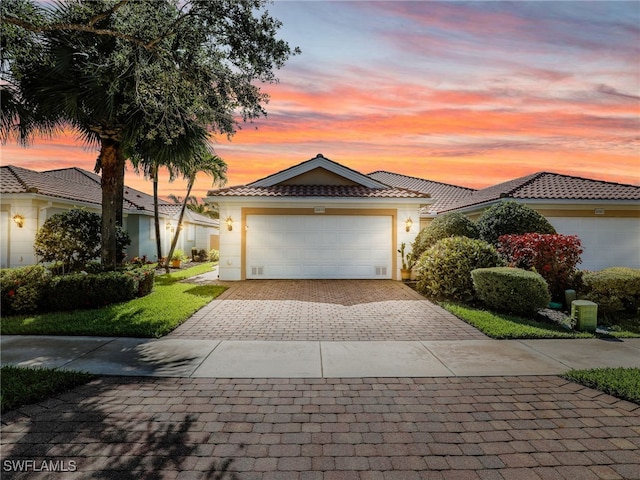 28979 Vermillion Ln, Bonita Springs, FL 34135 - view of front of house featuring stucco siding, decorative driveway, an attached garage, and a tile roof