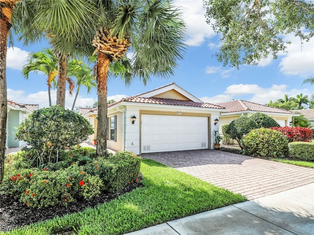 28979 Vermillion Ln, Bonita Springs, FL 34135 - mediterranean / spanish-style house with stucco siding, decorative driveway, an attached garage, and a tiled roof