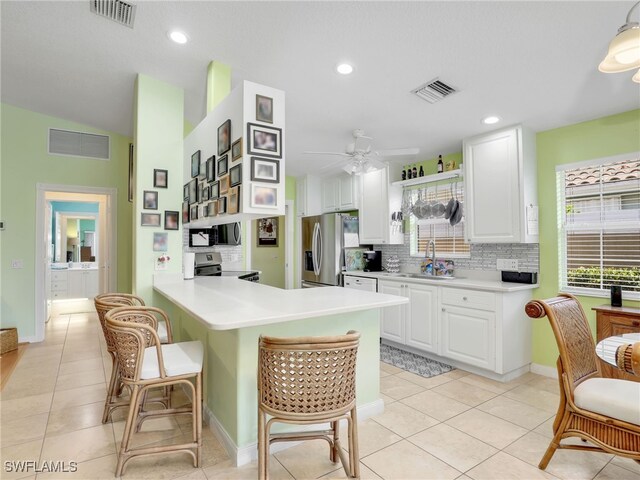 28979 Vermillion Ln, Bonita Springs, FL 34135 - kitchen with appliances with stainless steel finishes, a kitchen breakfast bar, backsplash, white cabinets, and recessed lighting
