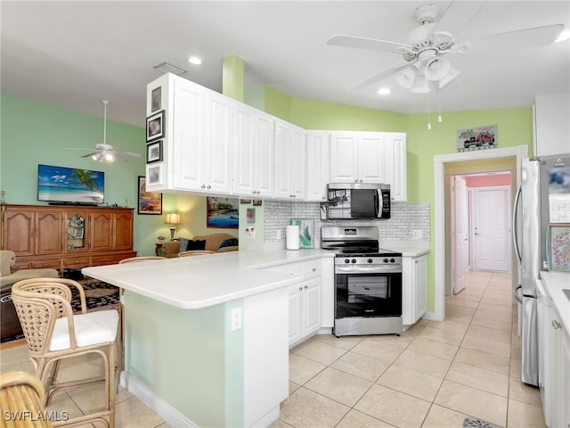 28979 Vermillion Ln, Bonita Springs, FL 34135 - kitchen with stainless steel appliances, ceiling fan, a peninsula, backsplash, and white cabinetry