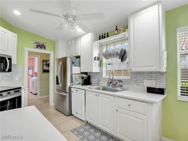 28979 Vermillion Ln, Bonita Springs, FL 34135 - kitchen with stainless steel appliances, decorative backsplash, light tile patterned flooring, washer / dryer, and white cabinets
