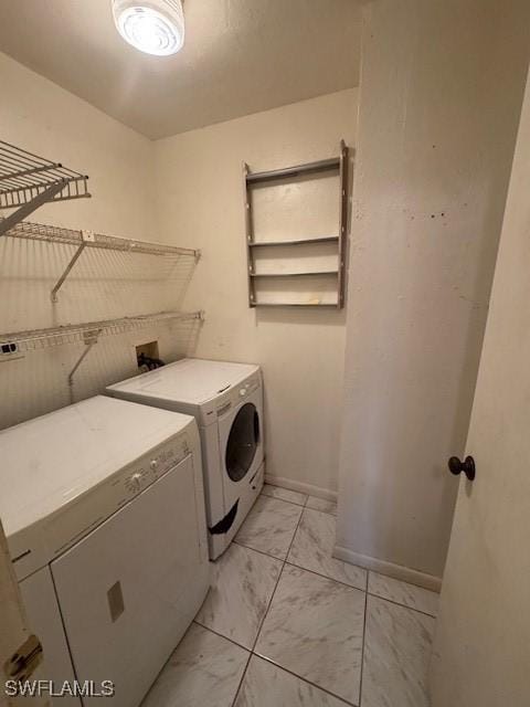 3911 Country Club Blvd Unit 102, Cape Coral, FL 33904 - washroom with separate washer and dryer, light marble finish flooring, and baseboards