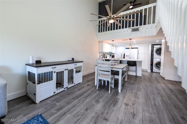 12964 Meadowood Ct, Fort Myers, FL 33919 - dining space with stacked washer / drying machine, a towering ceiling, dark wood-style flooring, baseboards, and ceiling fan