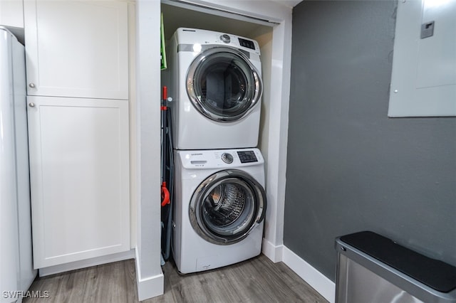 12964 Meadowood Ct, Fort Myers, FL 33919 - laundry room with stacked washer / drying machine, electric panel, wood finished floors, and baseboards
