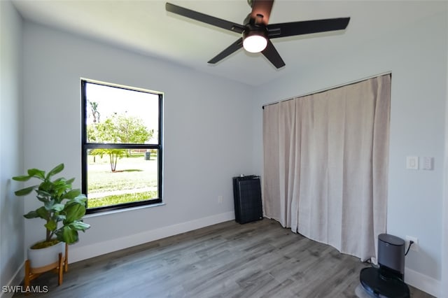 12964 Meadowood Ct, Fort Myers, FL 33919 - unfurnished bedroom featuring wood finished floors, baseboards, and a ceiling fan