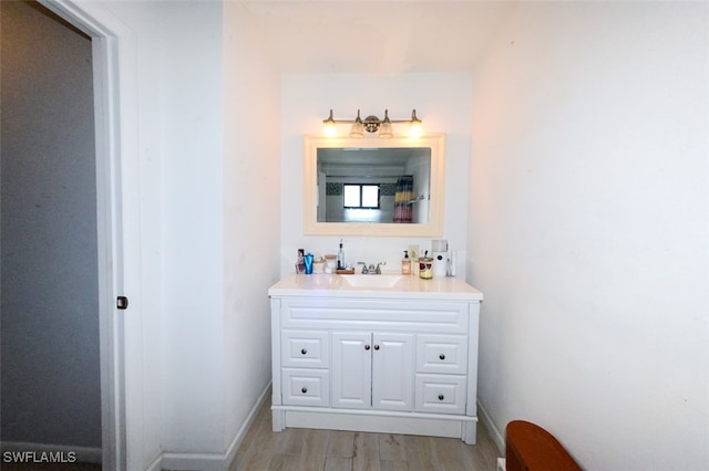 12964 Meadowood Ct, Fort Myers, FL 33919 - bathroom featuring vanity, wood finished floors, and baseboards