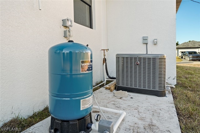 133 Fox Ave S, Lehigh Acres, FL 33974 - exterior view of central air condition unit, stucco siding, and a water pressure tank