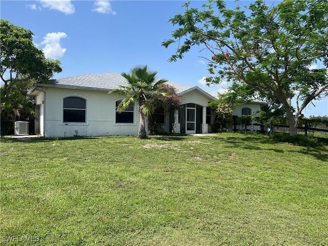 10551 Deal Rd, North Fort Myers, FL 33917 - rear view of property featuring central AC unit, stucco siding, and a yard