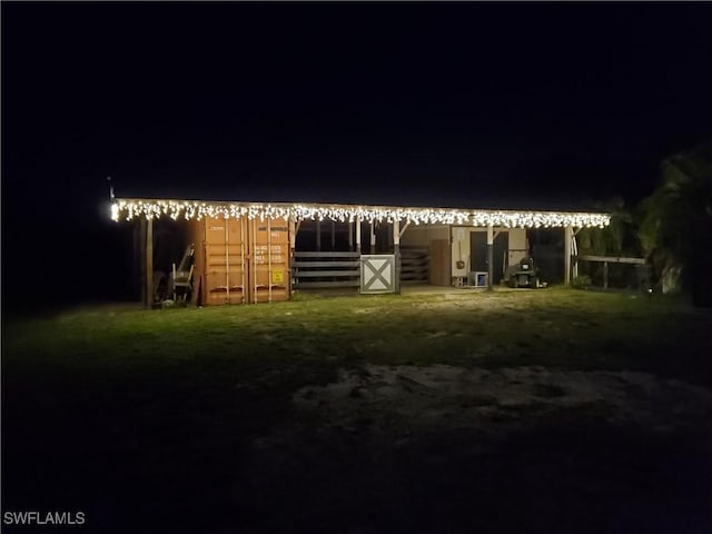 10551 Deal Rd, North Fort Myers, FL 33917 - back of house at twilight featuring an exterior structure and an outbuilding