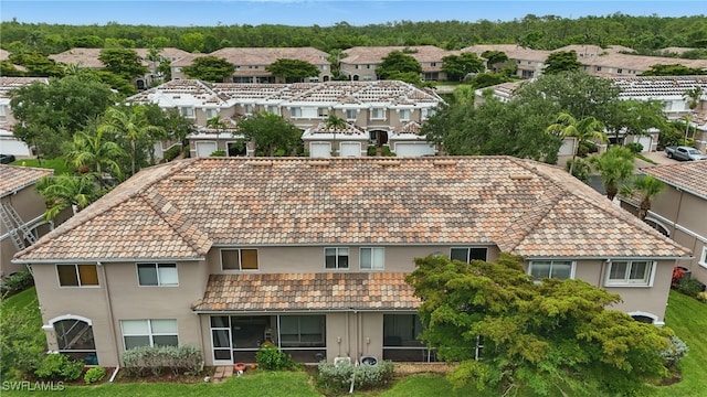 10020 Ravello Blvd, Fort Myers, FL 33905 - rear view of property with stucco siding, a residential view, a sunroom, and a tiled roof
