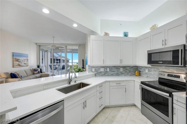 460 Launch Cir Ph 01, Naples, FL 34108 - kitchen with stainless steel appliances, a sink, light countertops, decorative backsplash, and white cabinetry