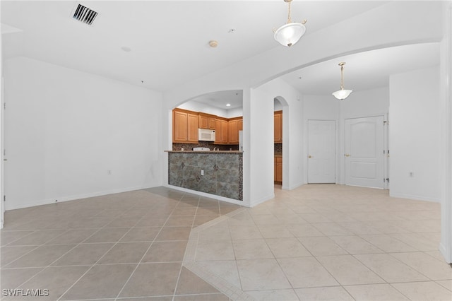 4381 Lazio Way Unit 501, Fort Myers, FL 33901 - unfurnished living room featuring light tile patterned floors, arched walkways, baseboards, and recessed lighting