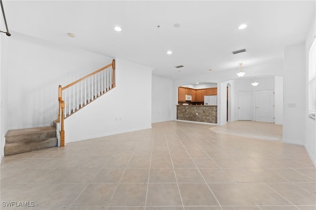 4381 Lazio Way Unit 501, Fort Myers, FL 33901 - unfurnished living room featuring arched walkways, stairway, recessed lighting, light tile patterned flooring, and baseboards