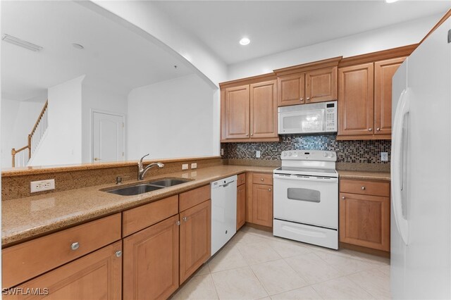 4381 Lazio Way Unit 501, Fort Myers, FL 33901 - kitchen featuring white appliances, a sink, light tile patterned floors, backsplash, and light stone countertops
