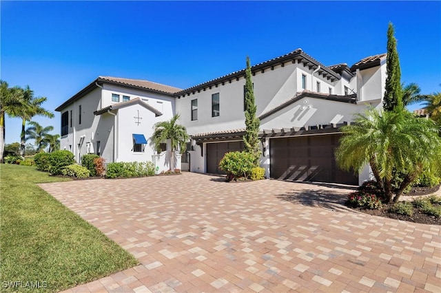 16304 Corsica Way Unit 101, Naples, FL 34110 - mediterranean / spanish home with a garage, stucco siding, a balcony, decorative driveway, and a front lawn