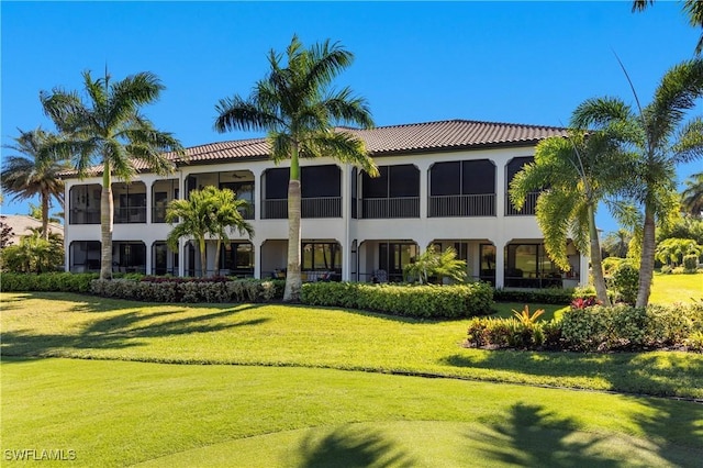 16304 Corsica Way Unit 101, Naples, FL 34110 - rear view of house with a yard, stucco siding, and a tile roof