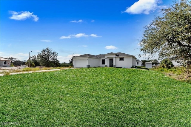 352 Rawlings Ave, Lehigh Acres, FL 33974 - view of front of property featuring an attached garage, a front yard, and stucco siding