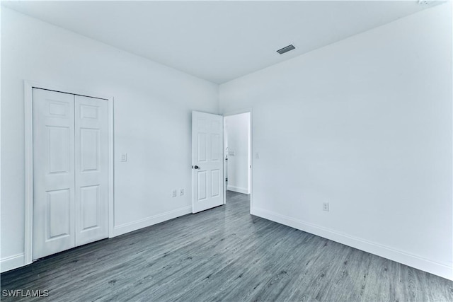 352 Rawlings Ave, Lehigh Acres, FL 33974 - unfurnished bedroom featuring wood finished floors, baseboards, and a closet