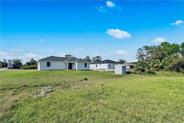 352 Rawlings Ave, Lehigh Acres, FL 33974 - back of house with a lawn