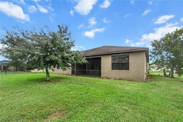 2211 SW 12th Ln, Cape Coral, FL 33991 - rear view of property featuring stucco siding and a sunroom