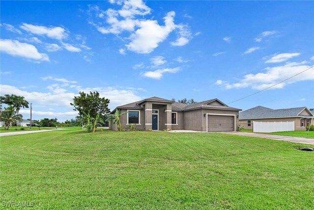 2211 SW 12th Ln, Cape Coral, FL 33991 - view of front facade featuring driveway, a front lawn, a garage, and stucco siding