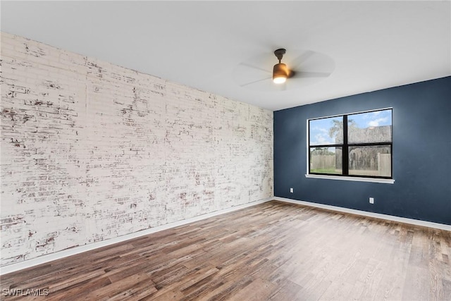 2211 SW 12th Ln, Cape Coral, FL 33991 - empty room featuring wood finished floors, a ceiling fan, and brick wall