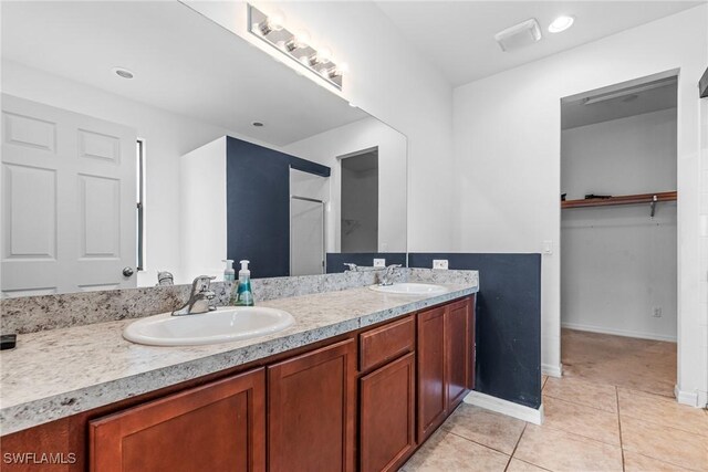 2211 SW 12th Ln, Cape Coral, FL 33991 - full bathroom featuring double vanity, tile patterned flooring, and a spacious closet