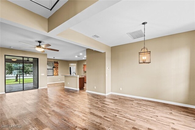2211 SW 12th Ln, Cape Coral, FL 33991 - unfurnished living room featuring a chandelier, light wood-type flooring, a ceiling fan, and recessed lighting