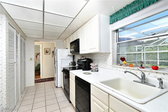 104 Waterview Ave, Lehigh Acres, FL 33936 - kitchen featuring black appliances, wallpapered walls, healthy amount of natural light, light countertops, and white cabinetry