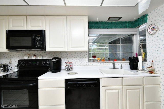 104 Waterview Ave, Lehigh Acres, FL 33936 - kitchen featuring black appliances, wallpapered walls, white cabinets, and light countertops