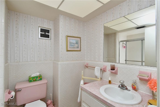 104 Waterview Ave, Lehigh Acres, FL 33936 - bathroom featuring vanity, a wainscoted wall, tile walls, and a shower with shower door