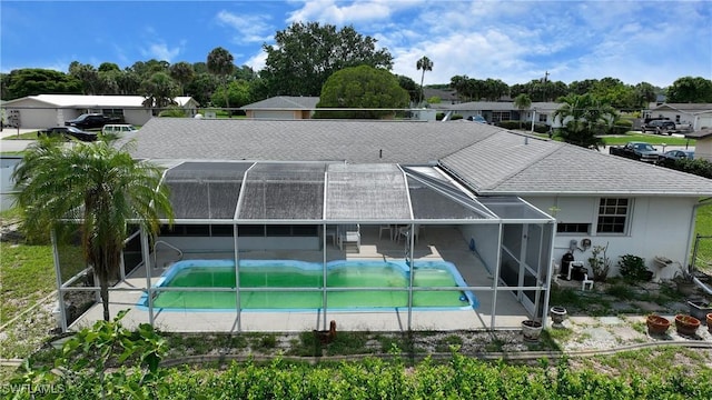 104 Waterview Ave, Lehigh Acres, FL 33936 - rear view of property featuring glass enclosure, an outdoor pool, a patio, and a shingled roof