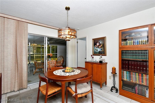104 Waterview Ave, Lehigh Acres, FL 33936 - tiled dining space featuring a chandelier and a textured ceiling