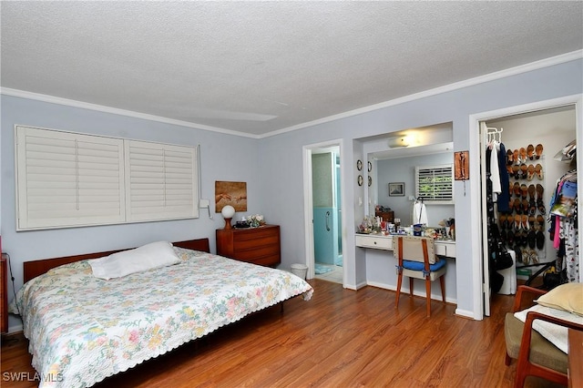 104 Waterview Ave, Lehigh Acres, FL 33936 - bedroom featuring a walk in closet, wood finished floors, a closet, ornamental molding, and a textured ceiling