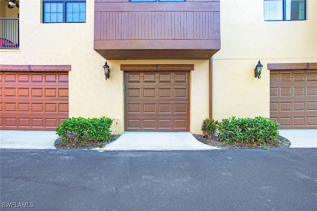 9065 Albion Ln N Unit 4909, Naples, FL 34113 - doorway to property featuring an attached garage, stucco siding, and a balcony
