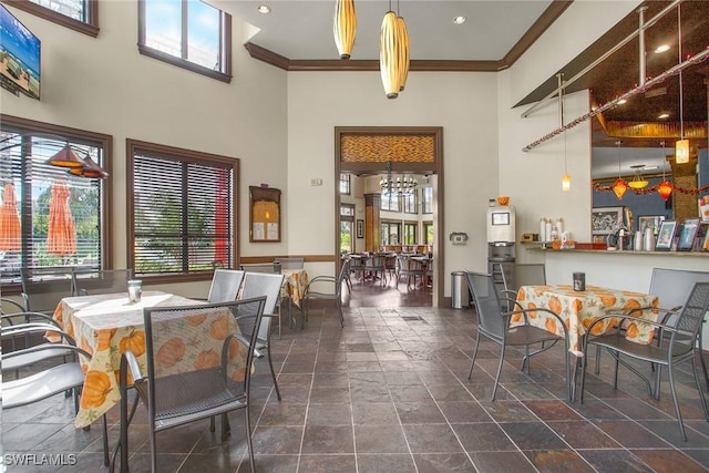 9065 Albion Ln N Unit 4909, Naples, FL 34113 - dining area with a high ceiling, stone tile flooring, plenty of natural light, ornamental molding, and a chandelier