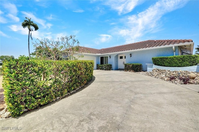 53 Madagascar Ct, Marco Island, FL 34145 - view of front facade with a tiled roof, an attached garage, concrete driveway, and stucco siding