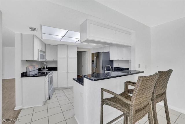 53 Madagascar Ct, Marco Island, FL 34145 - kitchen with range with electric cooktop, stainless steel refrigerator with ice dispenser, white microwave, a peninsula, and a breakfast bar area