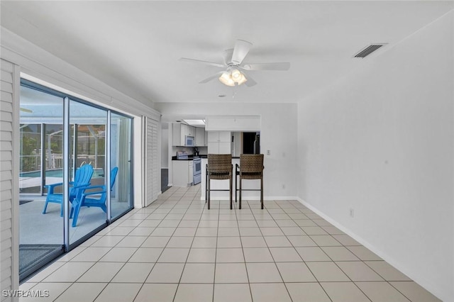 53 Madagascar Ct, Marco Island, FL 34145 - kitchen with stainless steel electric range, white microwave, a ceiling fan, white cabinetry, and refrigerator