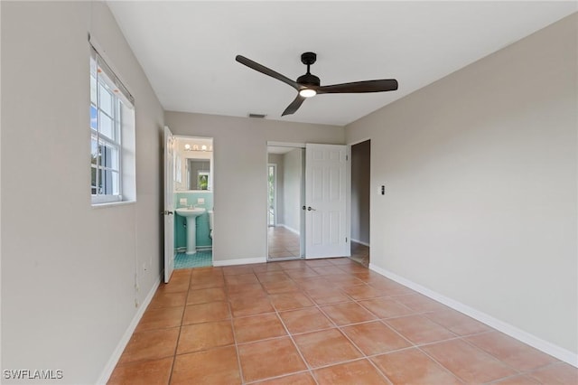 3018 Sunset Rd, Fort Myers, FL 33901 - unfurnished bedroom with light tile patterned floors, ensuite bath, and a ceiling fan