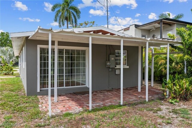 3018 Sunset Rd, Fort Myers, FL 33901 - view of side of property featuring stucco siding and a patio